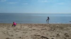 two people on the beach playing with a frisbee at Camping Siblu les Charmettes la Palmyre in Les Mathes