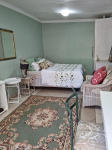 Victorian Villa Westdene Benoni في بينوني: غرفة نوم بسرير وطاولة وسجادة