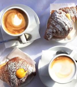a table with two cups of coffee and pastries at Fiorini Rooms Pescasseroli in Pescasseroli