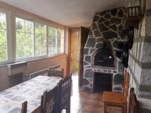 a dining room with a stone fireplace and a table at Los corzos in Burgohondo