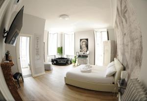 a white room with a bed and a living room at Apartments Chic Torino Centro in Turin