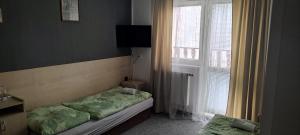 Habitación pequeña con cama y ventana en Penzion KASPEC, en Uničov