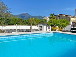 a large blue swimming pool with mountains in the background at Terrazza sul Vesuvio con piscina in Terzigno