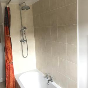 a bathroom with a shower and a tub and a sink at Abbot's Wing in Stroud