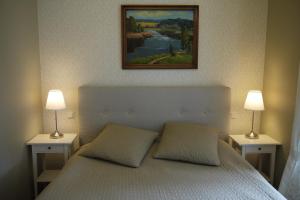 a bedroom with a bed with two lamps on it at Apartments Livia in Jūrmala