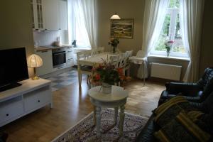 - un salon avec une table et des fleurs dans l'établissement Apartments Livia, à Jurmala