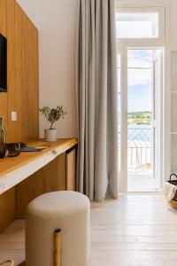 a room with a desk and a chair in front of a window at Casa Blue Sea View, Philian Collection in Skiathos Town