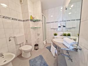 een witte badkamer met een wastafel en een toilet bij Hotel Sunce in Podstrana