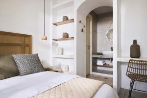 biała sypialnia z łóżkiem i krzesłem w obiekcie Antamoma Suites w mieście Kanala