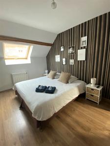 een slaapkamer met een groot bed en 2 handdoeken bij La Halte Effervescente in Épernay