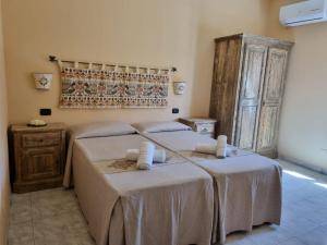 1 dormitorio con 2 camas y armario de madera en Hotel Plammas, en Santa Maria Navarrese