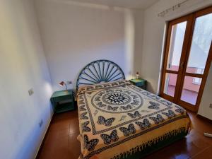 サンタ・テレーザ・ガッルーラにあるLa stella rosa sul mareのベッドルーム1室(ベッド1台、テーブル2台、窓付)