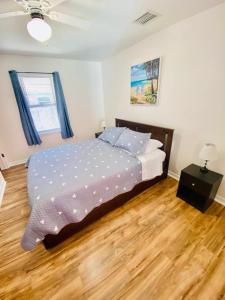 een slaapkamer met een bed en een houten vloer bij Two Fully Equipped Apartments and a Studio 5 miles from the beach in St Petersburg
