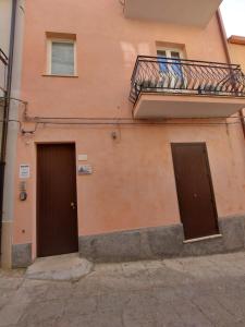 duas portas no lado de um edifício com uma varanda em Oikos - Ragusa Ibla em Ragusa
