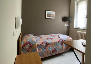 a bedroom with a bed and a table and a desk at Albergo del mera-ristorante da Lui in Sorico