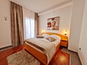 a bedroom with a bed and a large window at Hotel Sunce in Podstrana