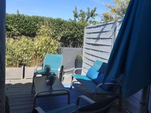 two blue chairs and chairs on a patio at Bord Verdon T2 Maisonnette 35m2 Climatisation - Terrasse 25m2-classé 3étoiles in Gréoux-les-Bains
