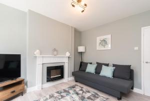a living room with a couch and a fireplace at Thurgarton House - Cosy and Calm 2bed in Nottingham