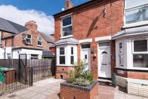 a red brick house with a white door at Thurgarton House - Cosy and Calm 2bed in Nottingham