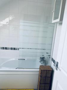 uma banheira branca numa casa de banho branca em Rosewood Guest House em Swindon