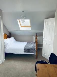 1 dormitorio con cama, mesa y ventana en Rosewood Guest House, en Swindon