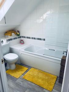 a bathroom with a white tub and a toilet at Rosewood Guest House in Swindon