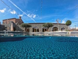 een zwembad met water voor een gebouw bij Etna Quota Mille Boutique Hotel, Typical Sicilian Food & Wine in Randazzo