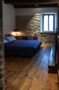 een slaapkamer met een bed en een stenen muur bij B&B Fonteabate Residenza di Charme in Bagno di Romagna