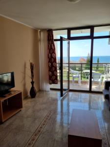 ein Wohnzimmer mit Fernseher und Balkon mit Aussicht in der Unterkunft Luxsus Apartment Diamond Sveti Vlas in Sweti Wlas