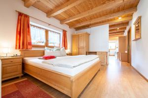 a bedroom with a large bed and a wooden ceiling at Unterhof in Riva di Tures