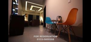 Una sala de estar con dos sillas y una mesa. en Serenity Corner, en Islamabad