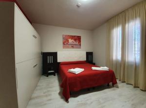 una camera con un letto rosso e una coperta rossa di Hotel Casale dei Greci a Biancavilla