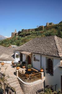 a house with a patio with a mountain in the background at Hotel SS KEKEZI in Gjirokastër