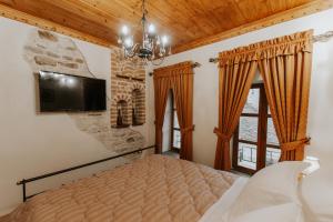 um quarto com uma cama e uma televisão na parede em Hotel SS KEKEZI em Gjirokastër mais 37 fotografias