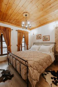 um quarto com uma cama grande e um tecto em madeira em Hotel SS KEKEZI em Gjirokastër