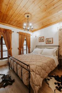 a bedroom with a large bed with a wooden ceiling at Hotel SS KEKEZI in Gjirokastër