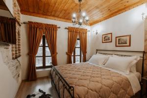 um quarto com uma cama grande e 2 janelas em Hotel SS KEKEZI em Gjirokastër