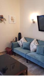 sala de estar con sofá azul y TV en Newly renovated house with pool, en Campagne-sur-Aude