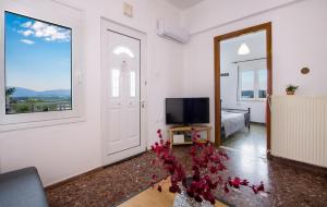 Habitación grande de color blanco con TV y dormitorio. en Plaka House en Plaka