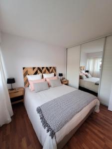 1 dormitorio con 1 cama grande y espejo grande en Havre de paix 4 étoiles, à 100 mètres de la plage, en Saint-Georges-de-Didonne