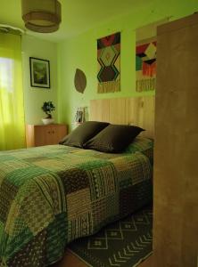 a bedroom with a bed with green walls at TY BIHAN TAD-KOZH in Ploumagoar