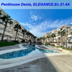a swimming pool with palm trees in front of some buildings at Sea view Penthouse Denia, ELEGANCE in Denia