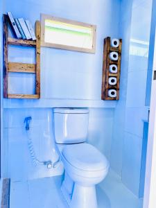 a bathroom with a white toilet in a room at Hiraeth island home in Guraidhoo