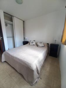 - une chambre avec un lit blanc et 2 oreillers dans l'établissement Refugio del visitante, à Chascomús