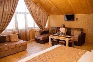 a woman sitting on a couch in a room at View point by HarMar hotels in Goris