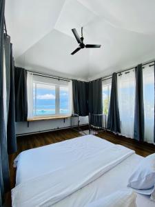 グライドゥにあるHiraeth island homeのベッドルーム1室(大型ベッド1台、シーリングファン付)