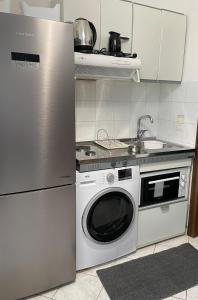 een keuken met een koelkast en een wasmachine bij ALEKA KOTSI ROOMS 2 in Igoumenitsa