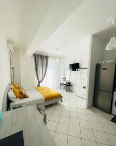 een witte kamer met een bed en een keuken bij ALEKA KOTSI ROOMS 2 in Igoumenitsa