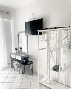 a white room with a desk and a table at ALEKA KOTSI ROOMS 2 in Igoumenitsa