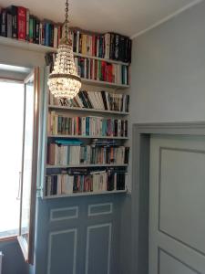 une étagère remplie de livres à côté d'une porte dans l'établissement 3 Place des Arbres, Chambres D'Hôtes, Felletin, à Felletin